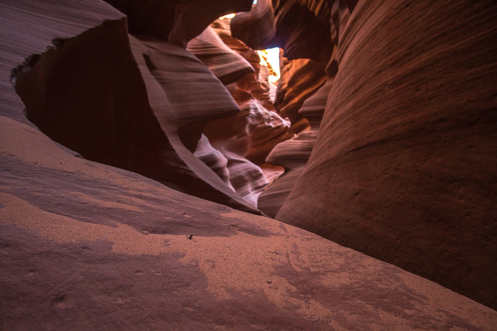 Some of the very fine sand in Lower Antelope Canyon on a rock looking back into the narrow slot canyon