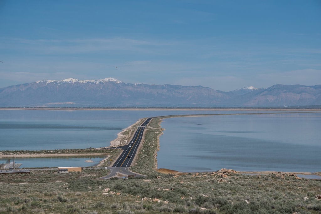 The long causeway to Antelope Island State Park with water on both sides and mountains in the background