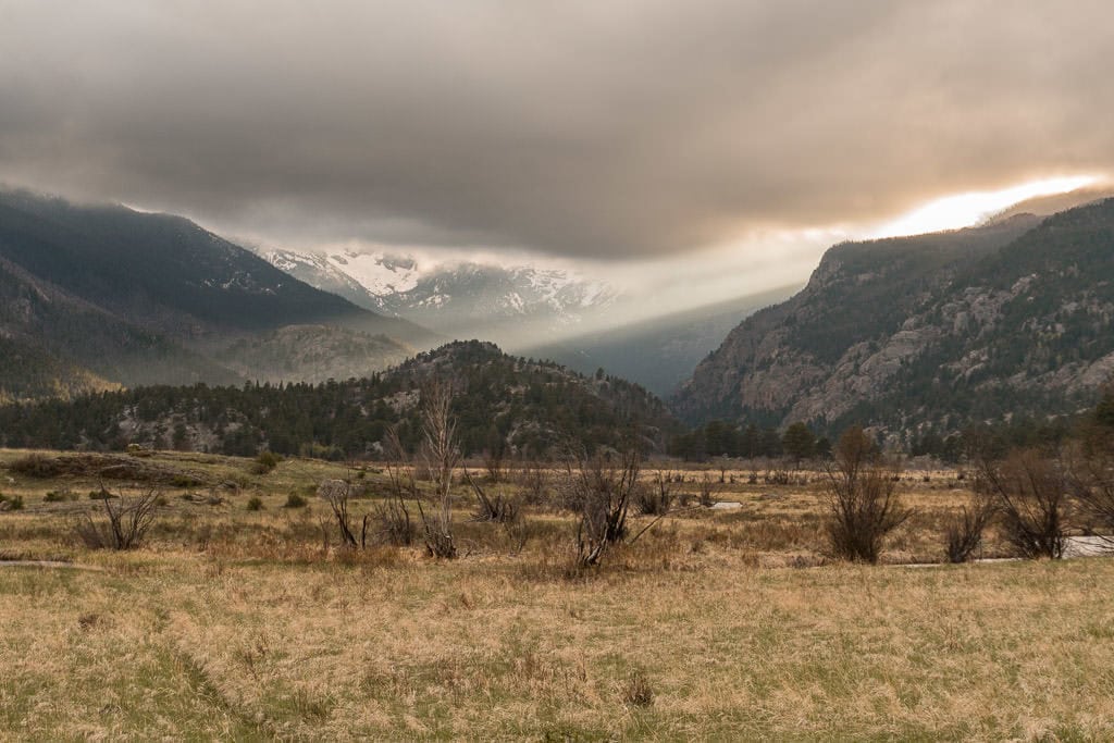 sunset through the mountains in spring in rocky mountain national park