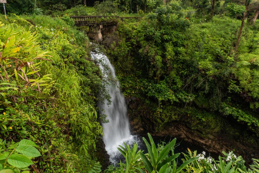 Waterfall going under a bridge on the Road to Hana in Maui