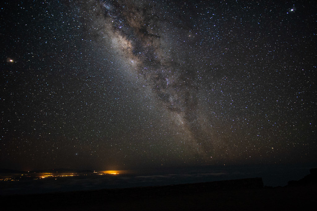 Milky Way and stairs with city lights in the distance from the Haleakala summit