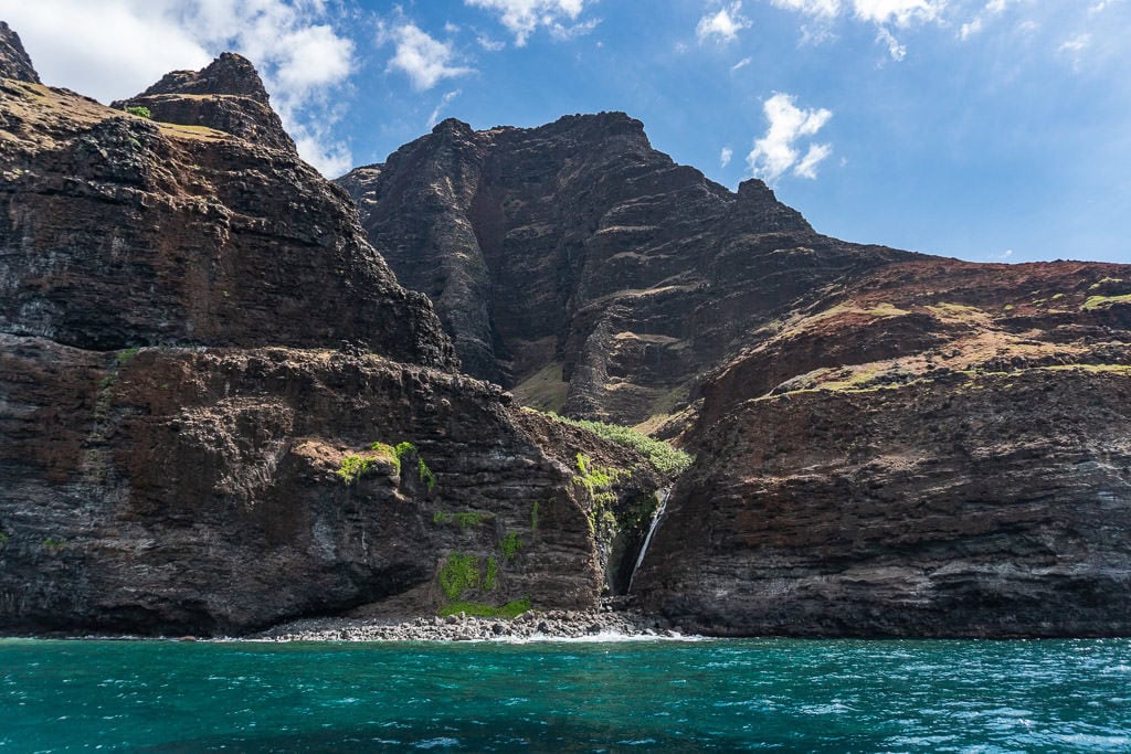 mini waterfall with scenic views on napali coast boat tour in Kauai