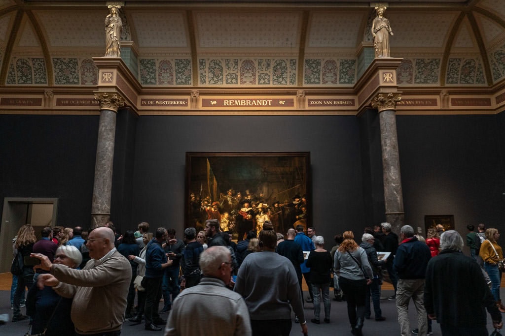 crowds looking at a large Rembrandt 'Night Watch' painting at Rijksmuseum in amsterdam