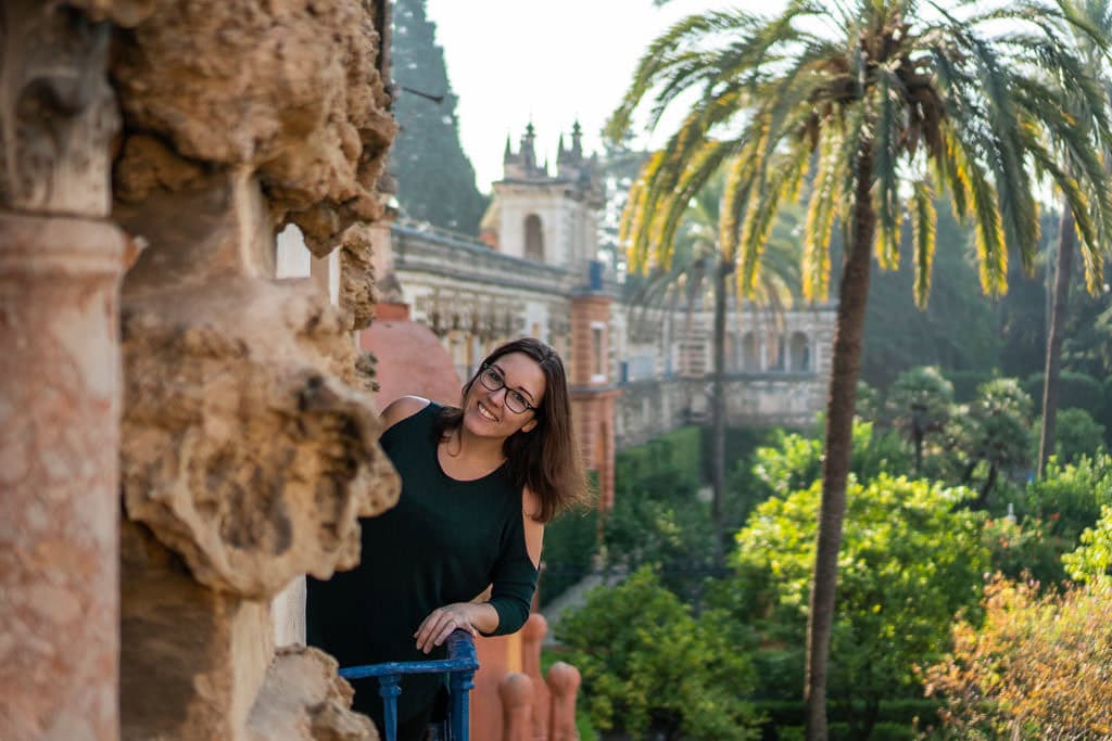 leaning over railing at ornate park at the real alcazar in seville spain