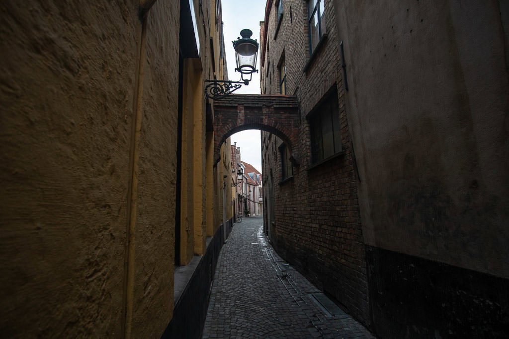 side street and arch in bruges belgium