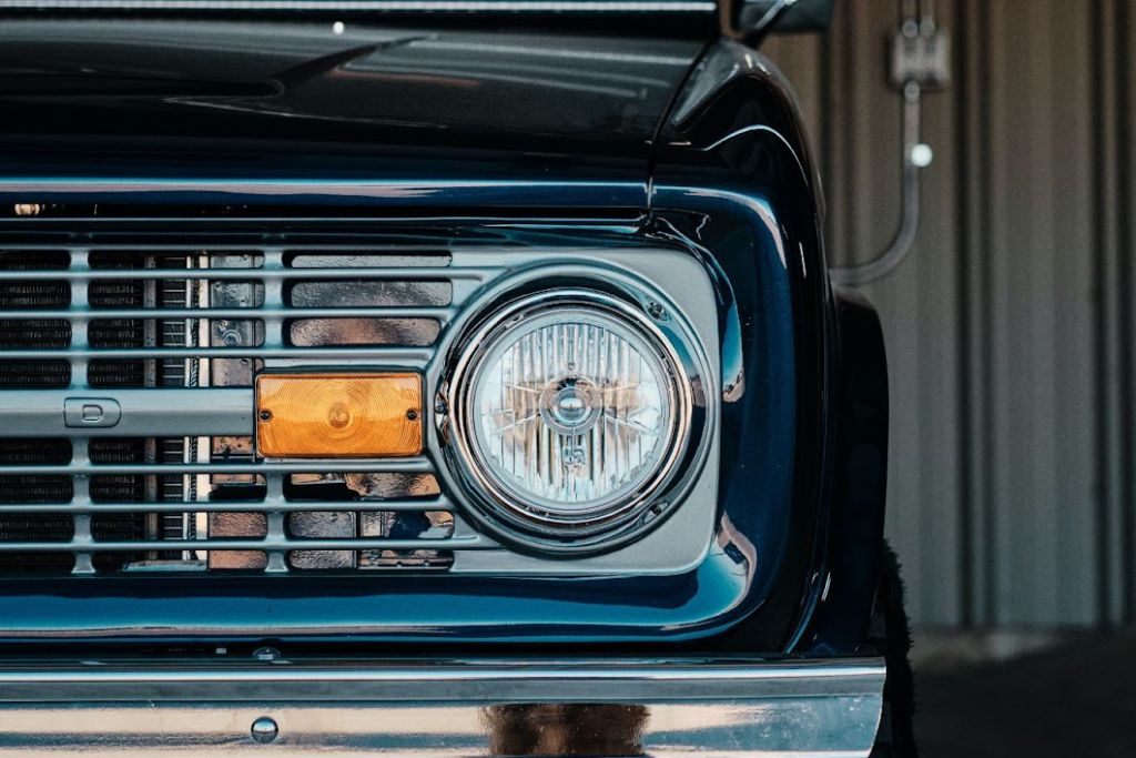 front view of an older truck with a new headlight bulb on the driver's side