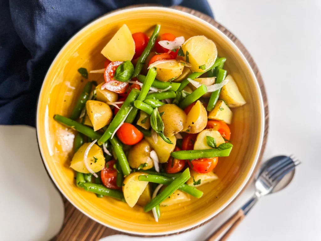 Italian Potato Salad in a yellow serving bowl