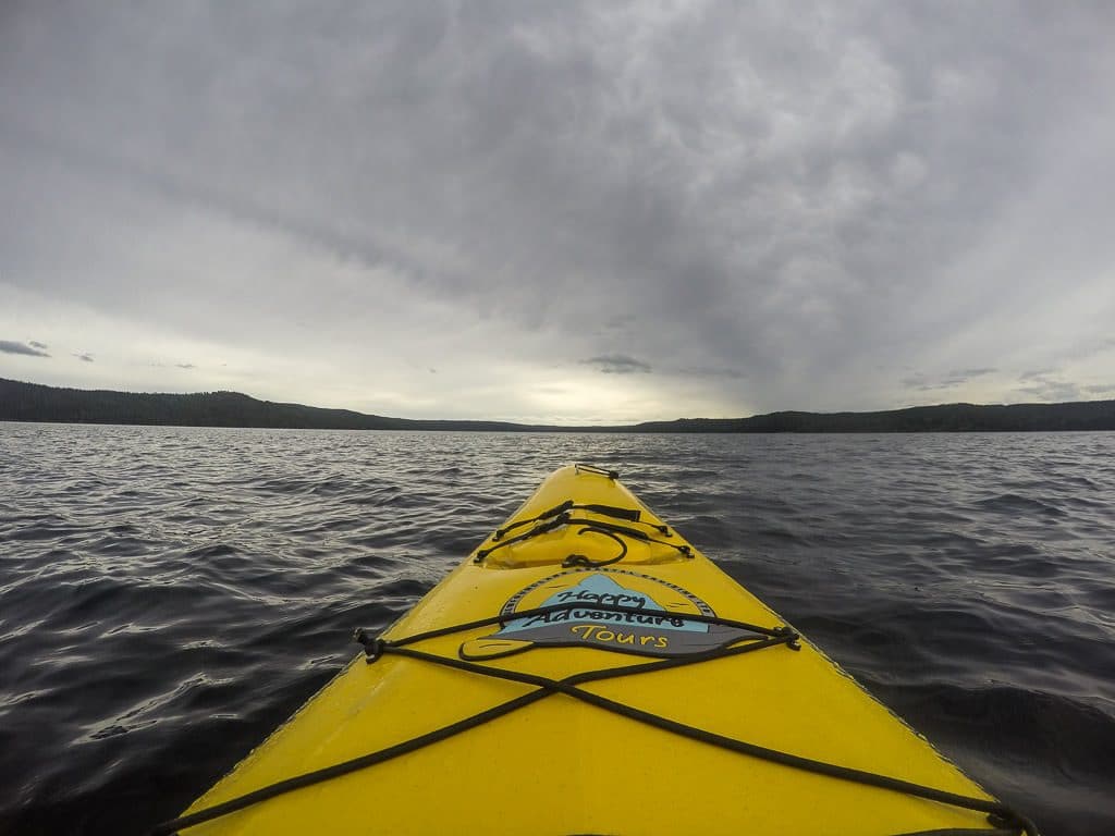 Front of the kayak in the open ocean with the Happy Adventure Tours logo