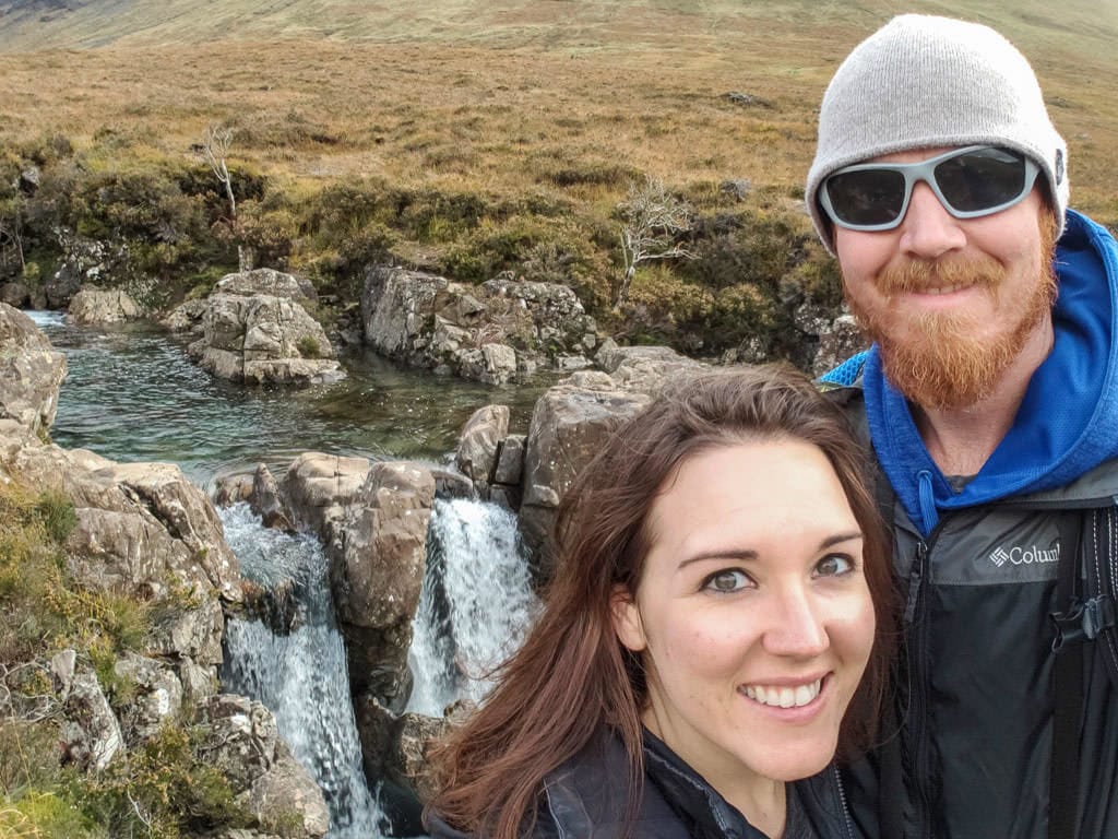 Brooke and Buddy next to a waterfall at Fairy Pools in Isle of Skye