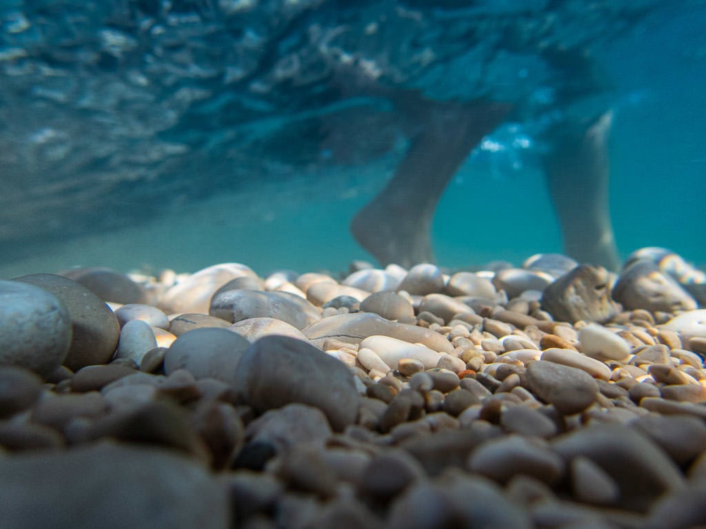 Brooke walking in the water and rocks at Sulić Beach