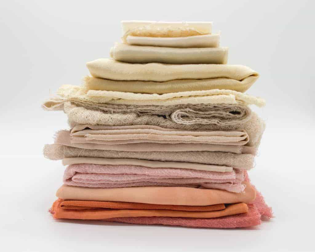 Buy Fabric Online - Stack of white and pink fabric