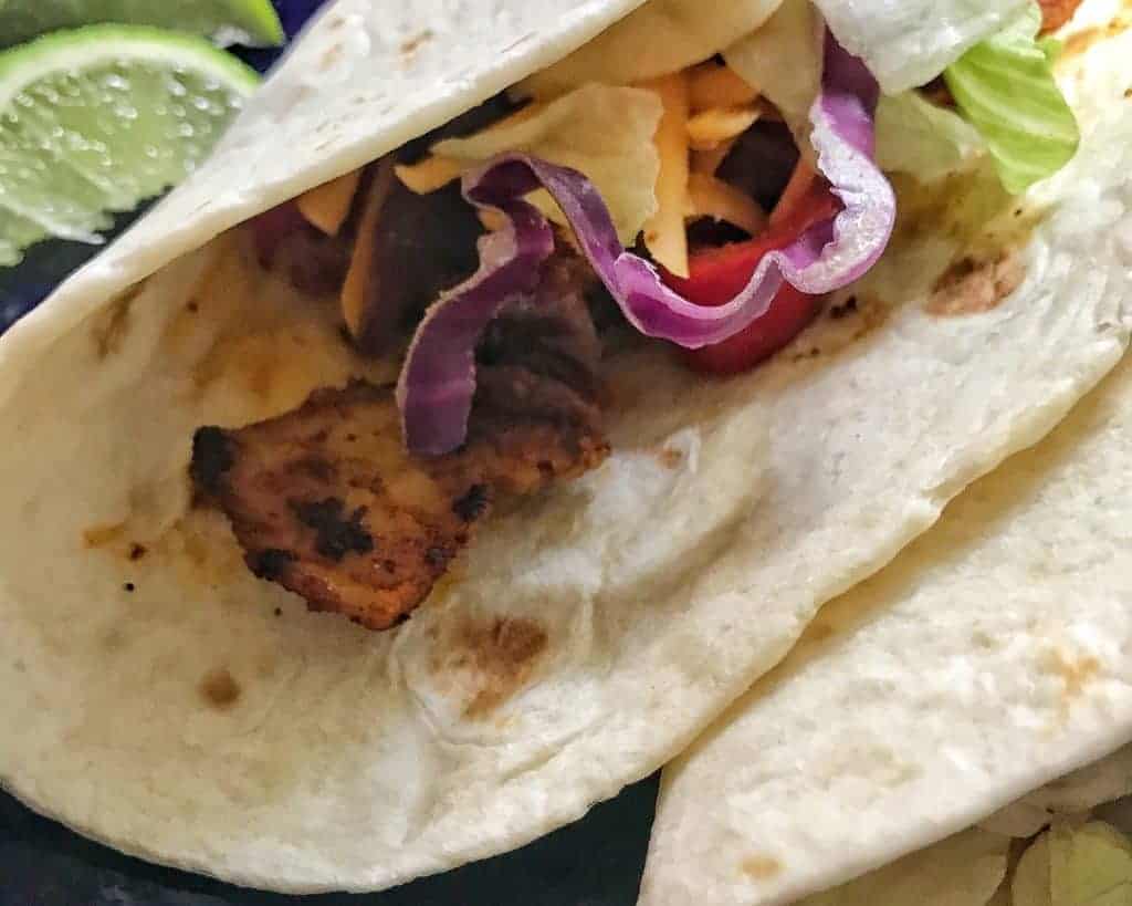 Chicken, bell peppers, and onions in flour tortilla
