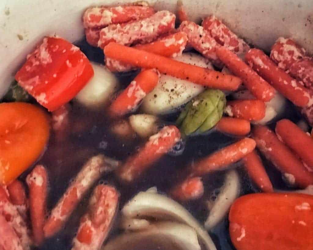 vegetables, flour, and beef broth in pot