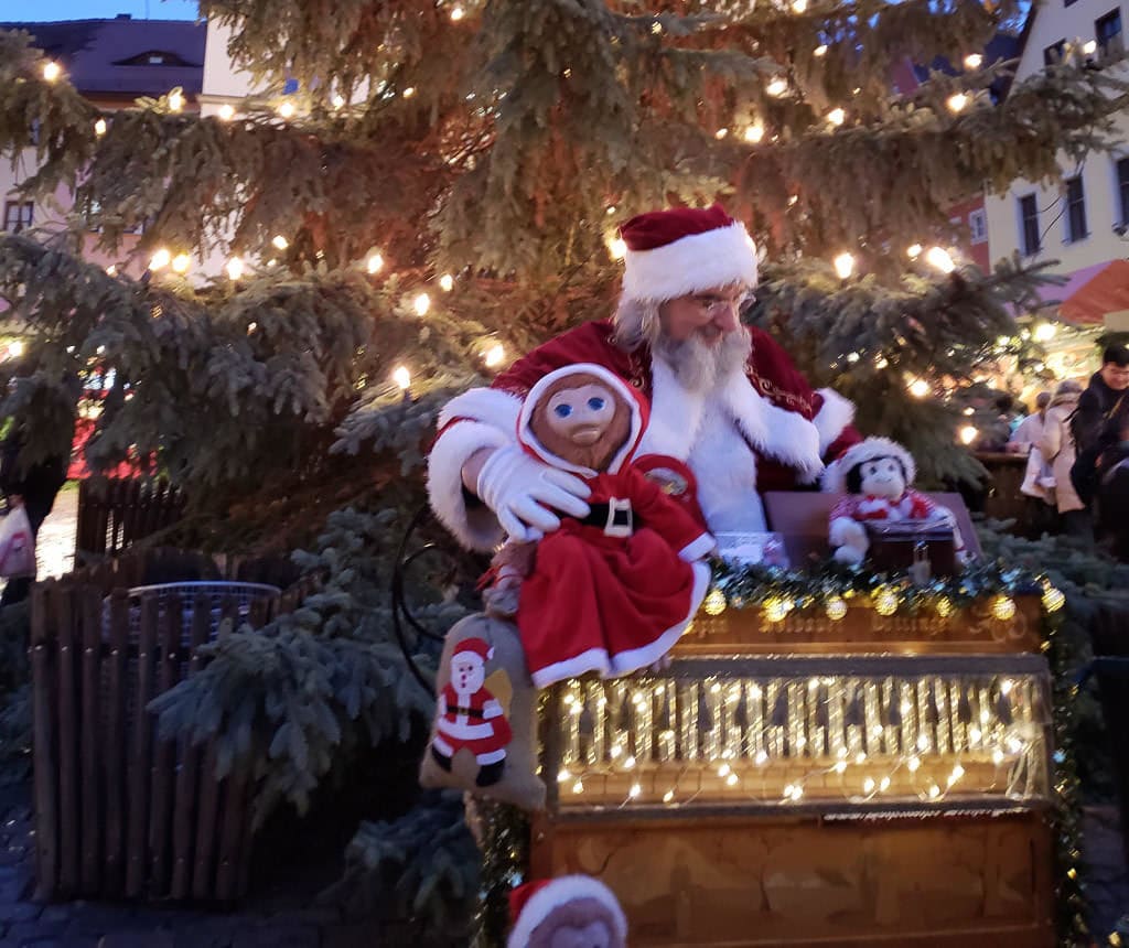 santa hand-cranking music at christmas market in rothenburg germany