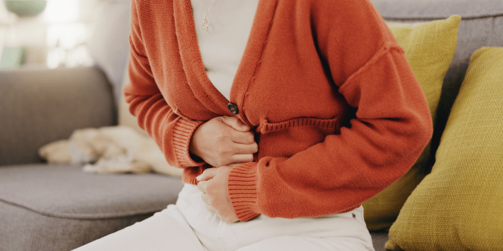 woman with ibs holding her stomach in pain looking for natural ibs relief
