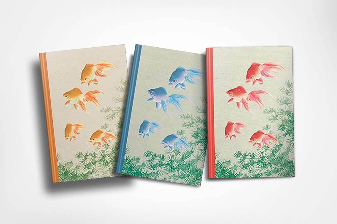 Three goldfish-themed journals in orange, blue, and gold designs, displayed in a row with aquatic plant motifs.