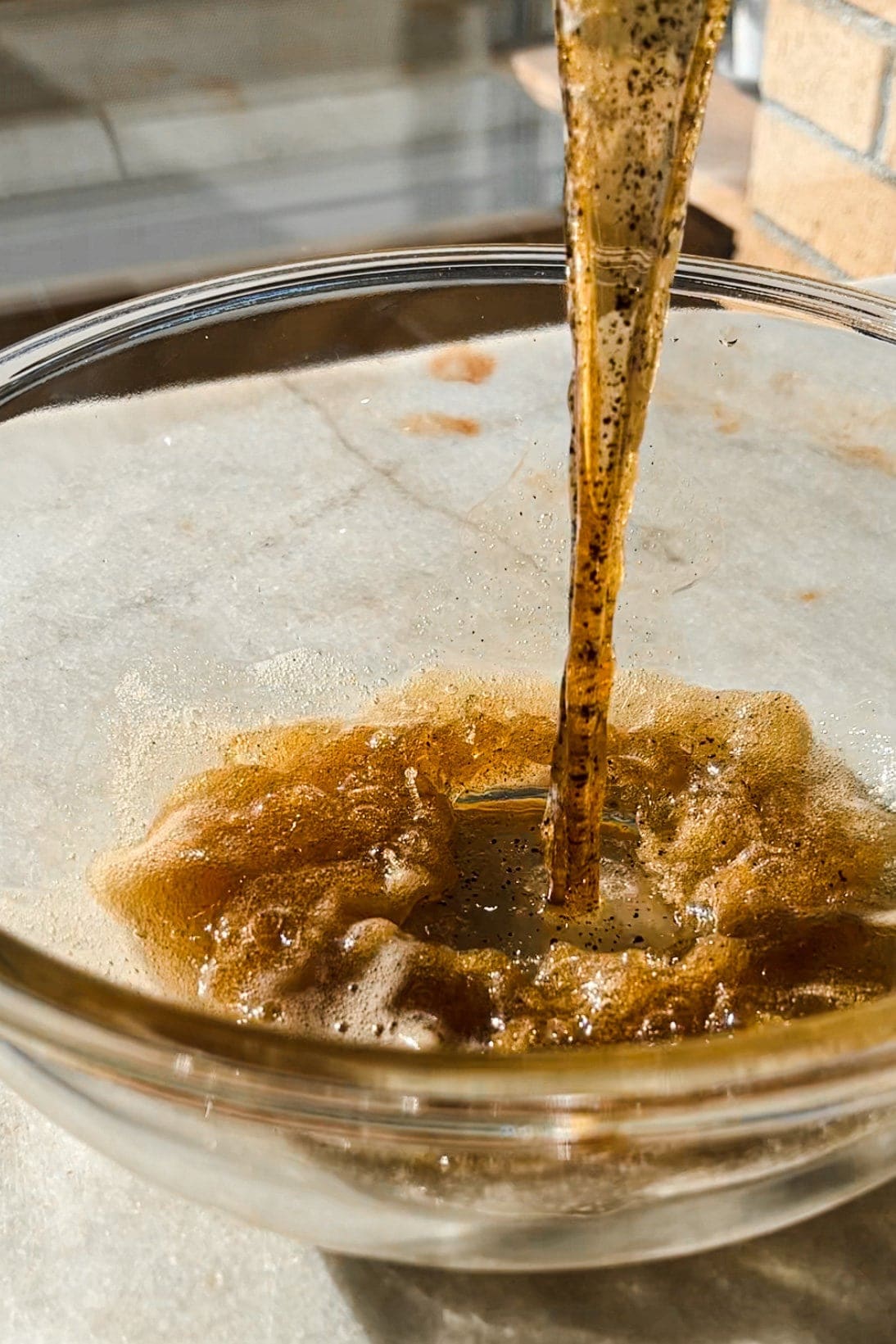 Brown butter being poured into a glass bowl for the Brown Butter Oatmeal Chocolate Chip Cookies. | Paula's Apron Recipe