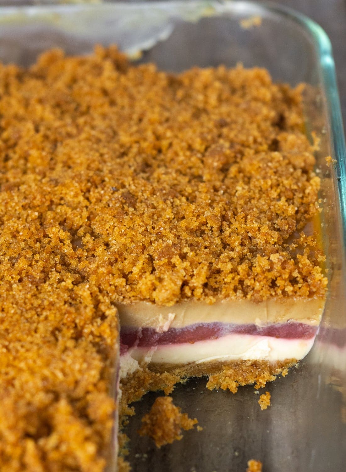 Vegan gluten-Free peanut butter lasagna garnished with strawberry slices on a white plate on a wooden board