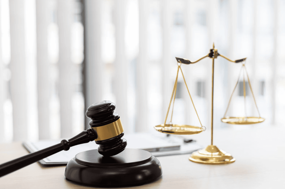 Richterhammer und Balkenwaage stehen auf einem Tisch - Testamentsvollstreckung