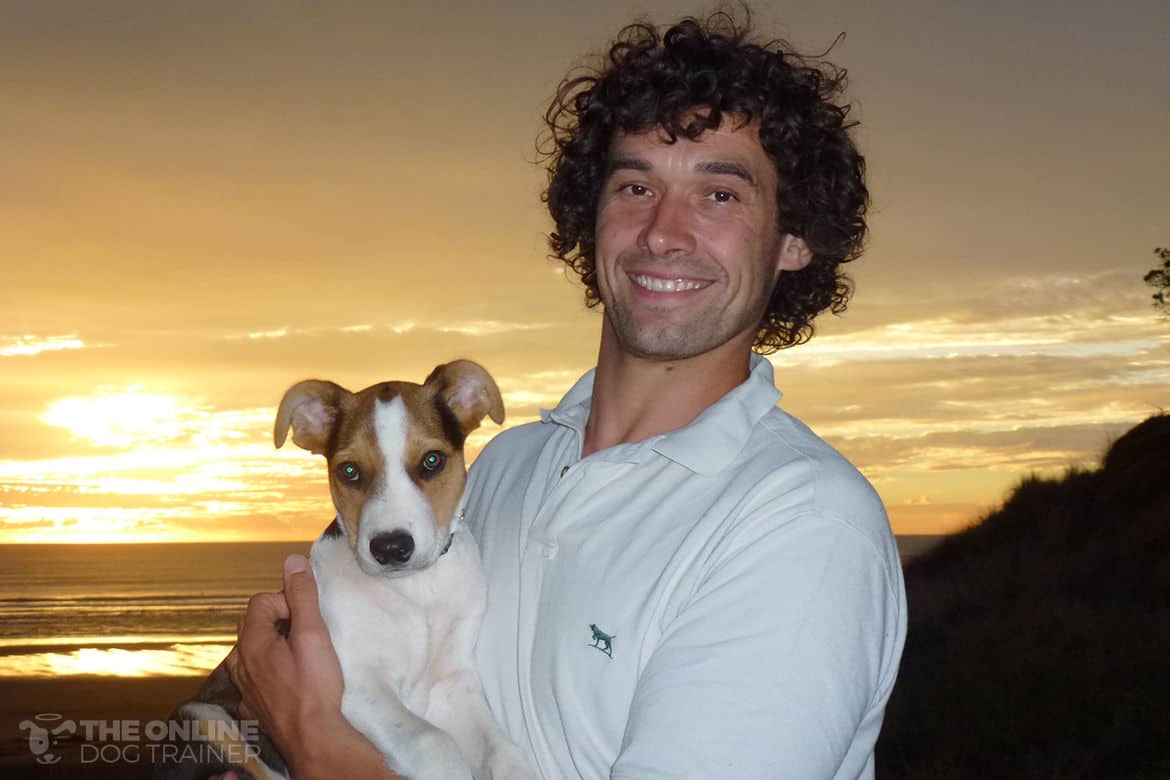 Doggy dan holding puppy Moses against a sunset background