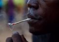 A young man smokes Kush, a derivative of cannabis mixed with synthetic drugs like fentanyl and tramadol and chemicals like formaldehyde, at a hideout in Freetown, Sierra Leone, April 29, 2024 © Misper Apawu, AP