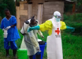 A health worker sprays disinfectant on his colleague after working at an Ebola treatment center in Beni, eastern Congo (AP)