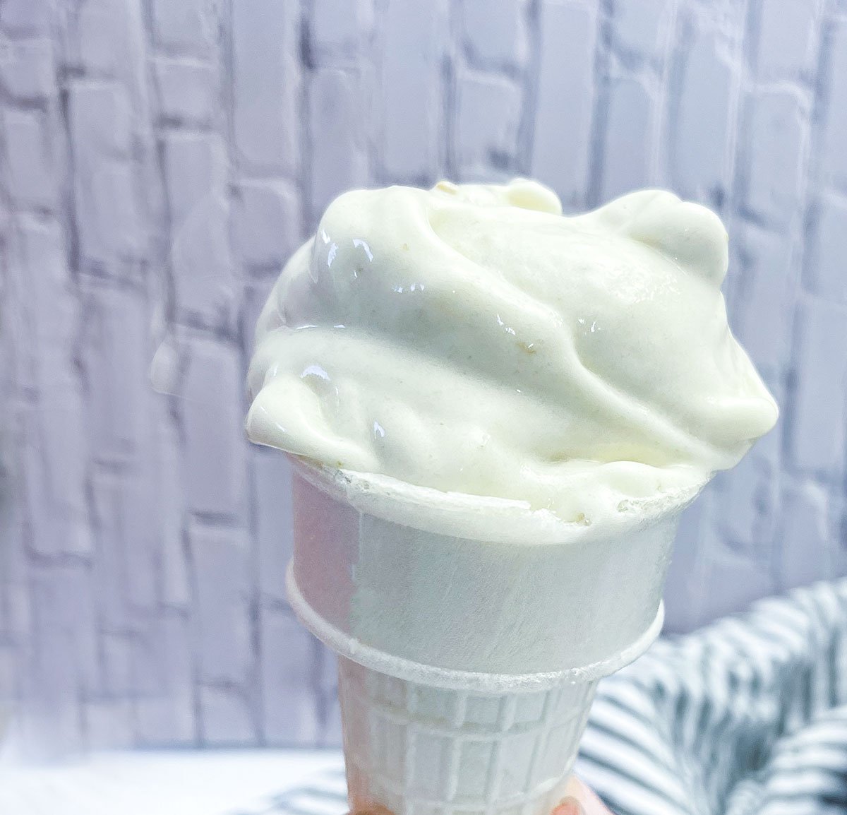 vegan banana ice cream in a cone with a white background