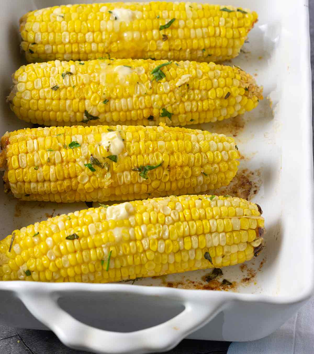 Close up baked corn in a white baking dish