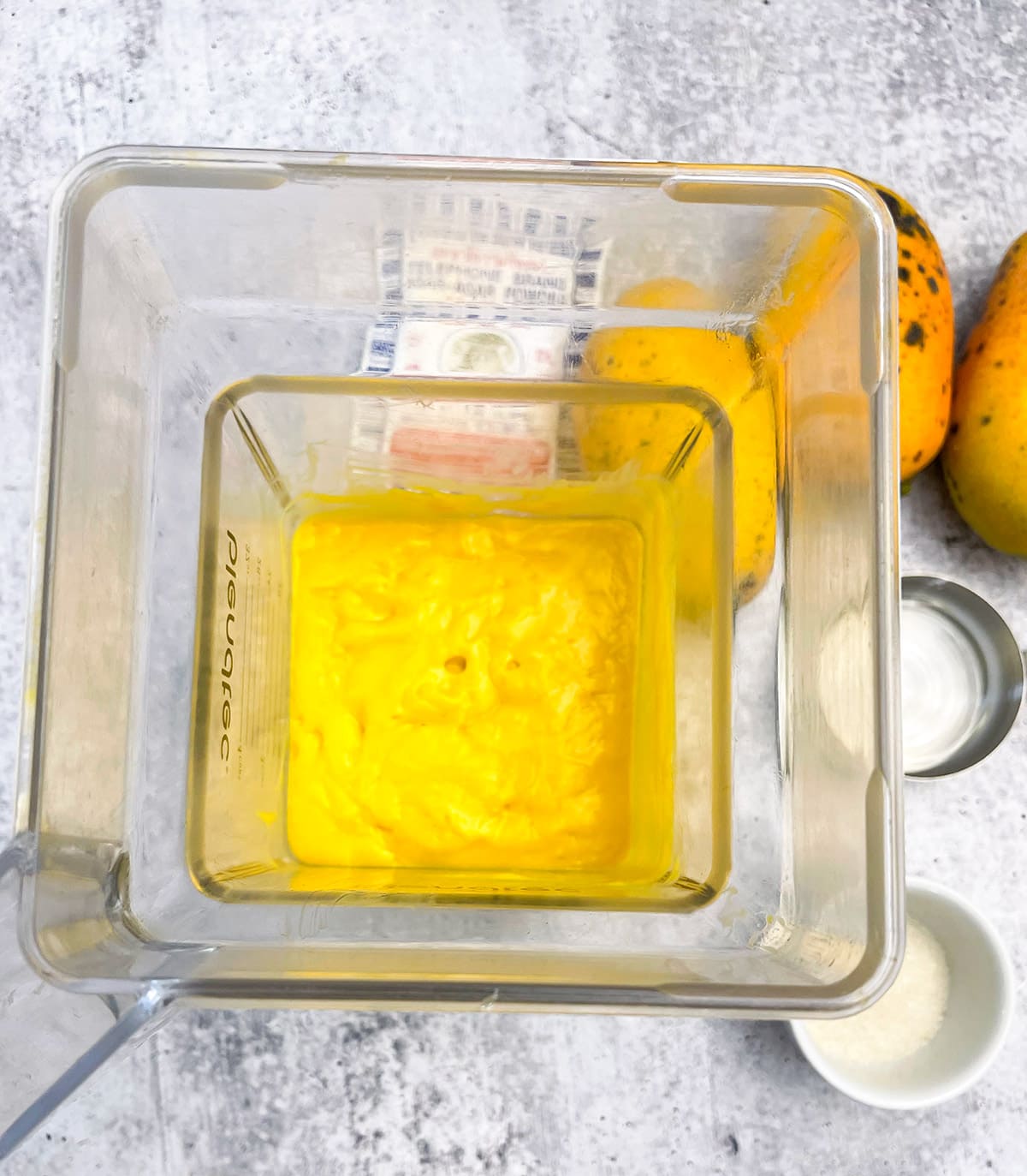 mango puree in the blender on grey background