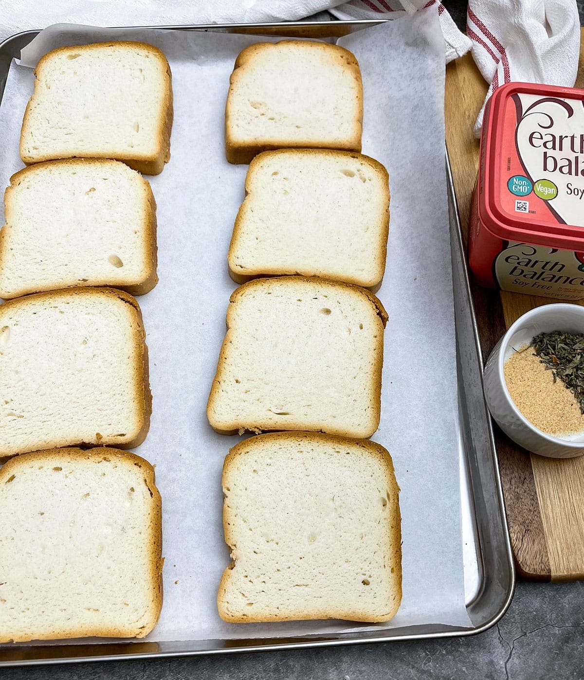 Texas toast slices on baking sheet with seasoning and vegan butter