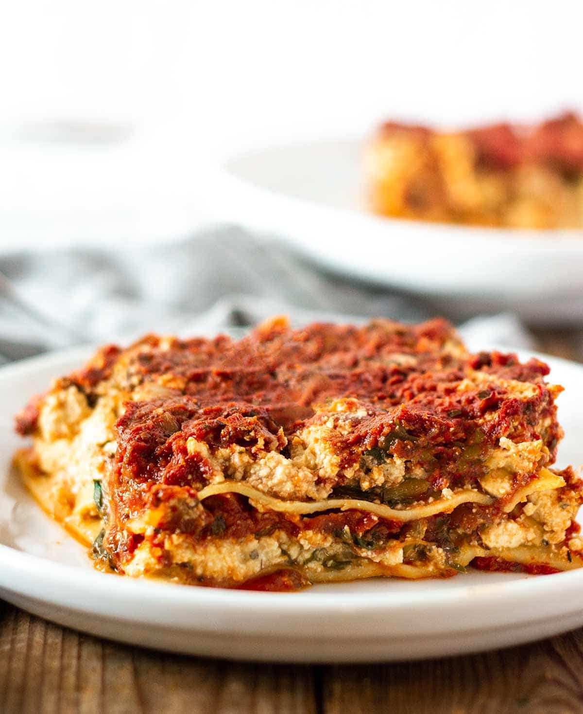 a slice of gluten free lasagna on a white plate