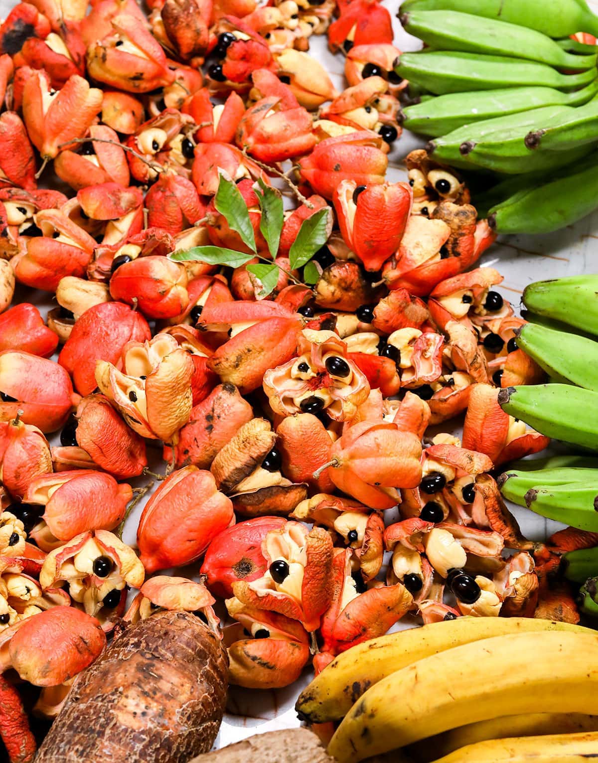 ackee on a wooden background with green bananas and plantain