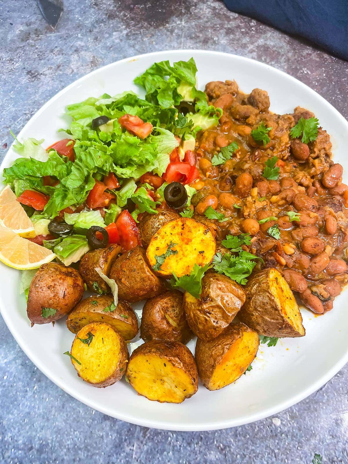 air fryer potatoes on a white plate with beans and salad