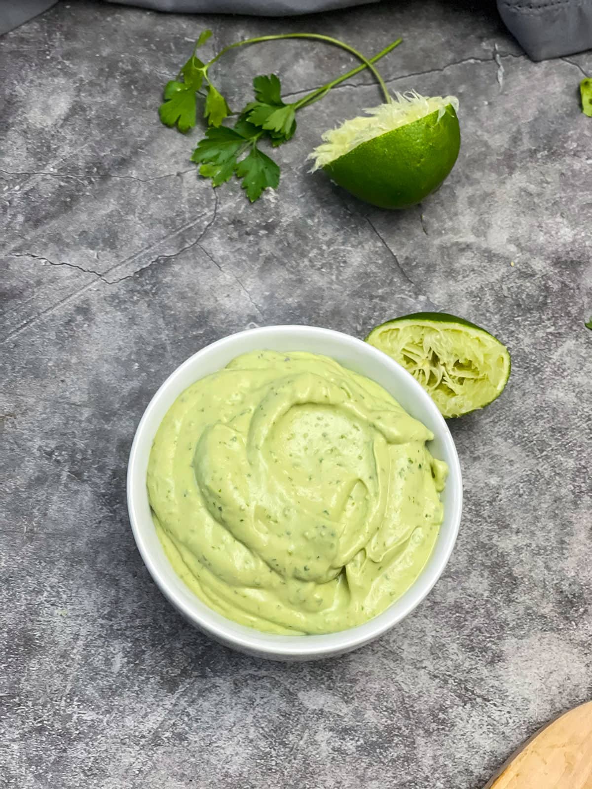 overlay avocado lime sauce in a white bowl on a grey background