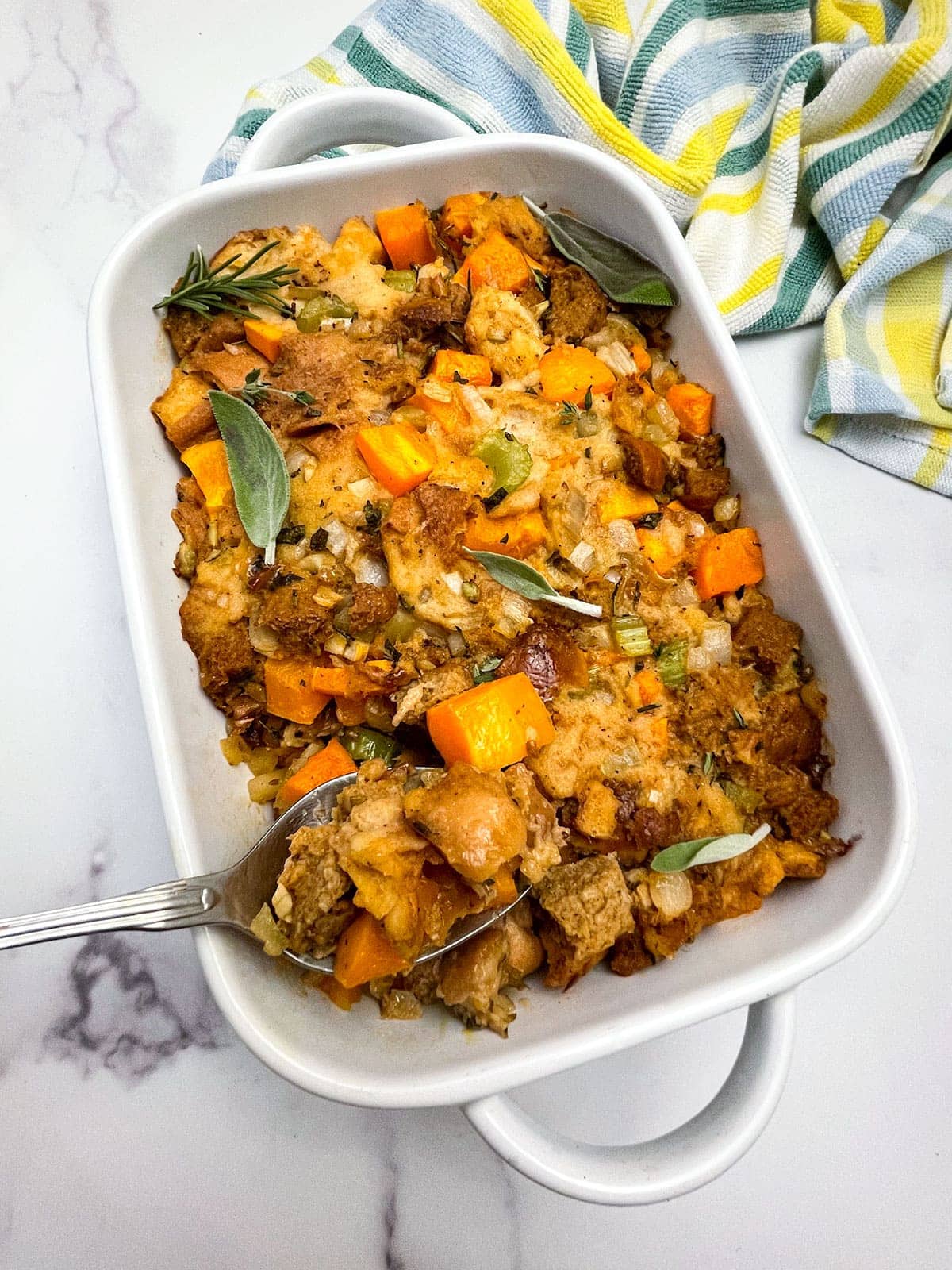 butternut squash stuffing in a white casserole pan on a white background