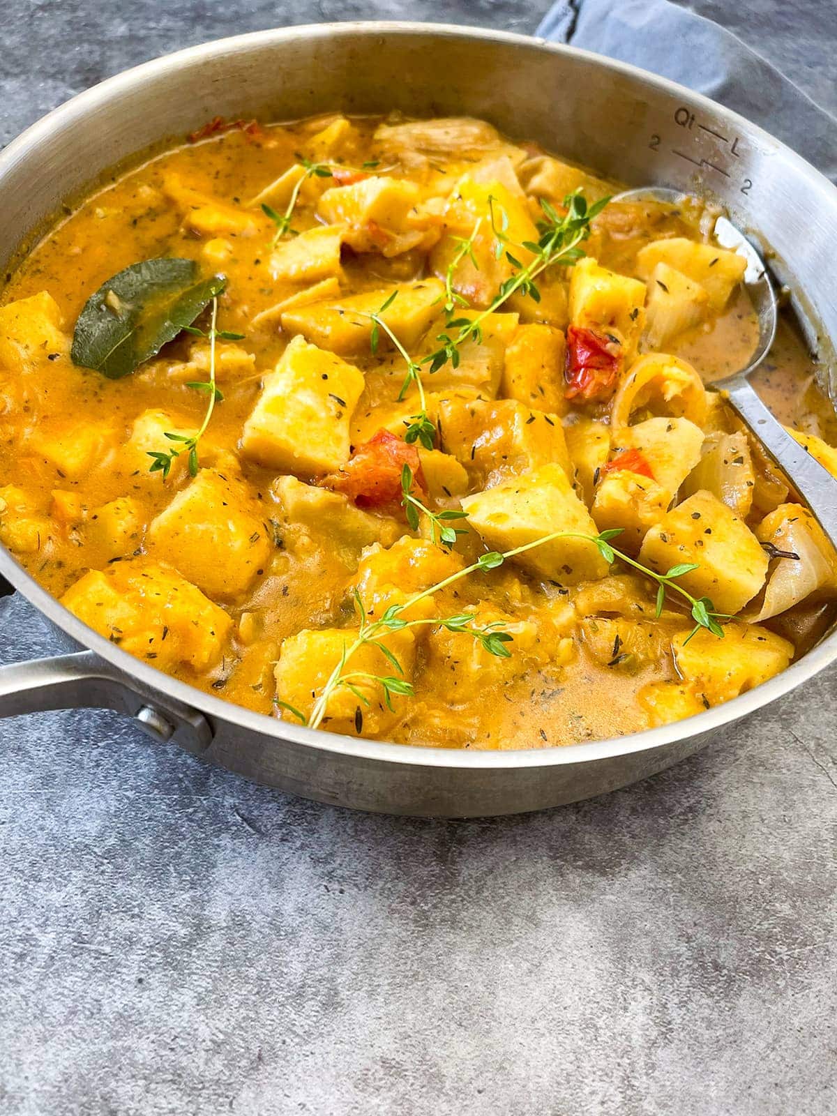white yam stew straight on in a saucepan on a grey background