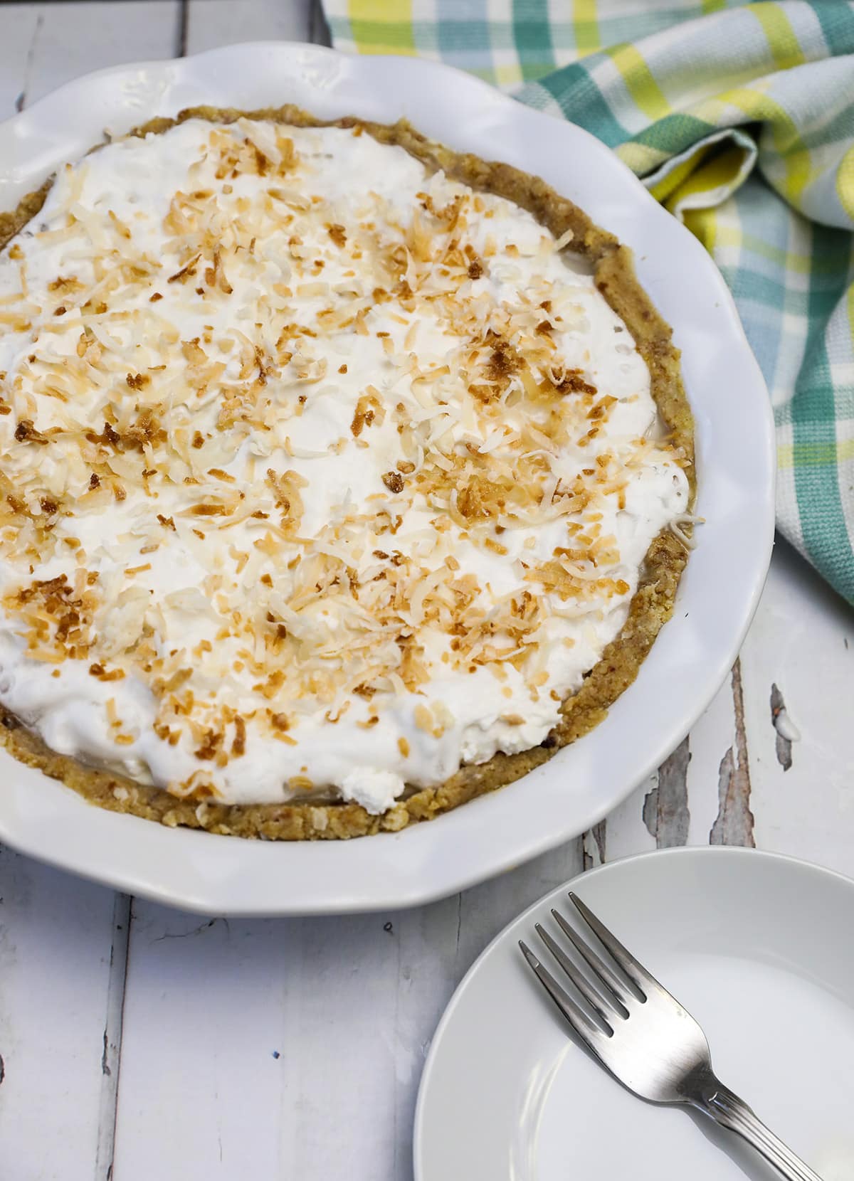 overlay coconut pie on a white wooden board