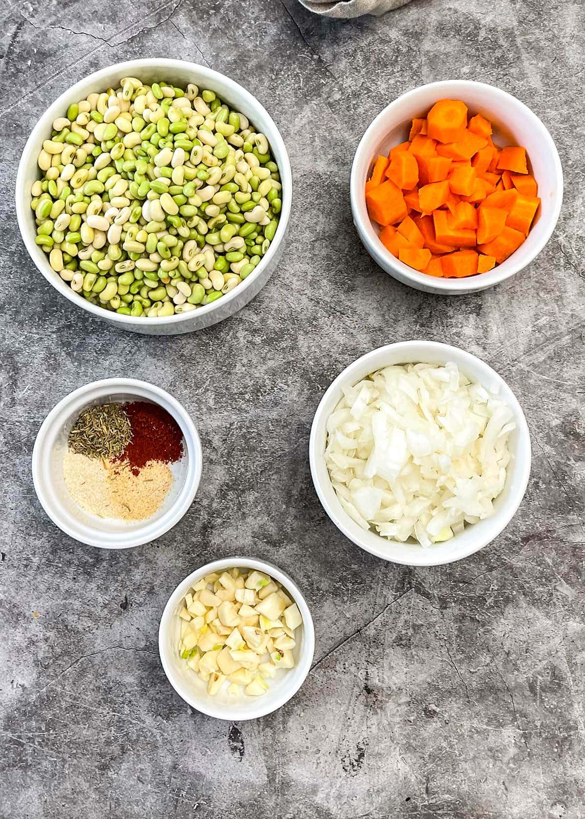 ingredient for white acre peas in white bowls on grey background