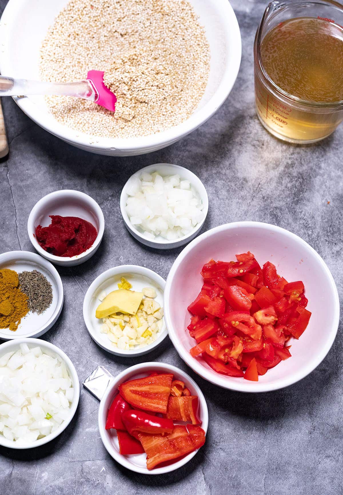 ingredients for jollof quinoa on a grey background