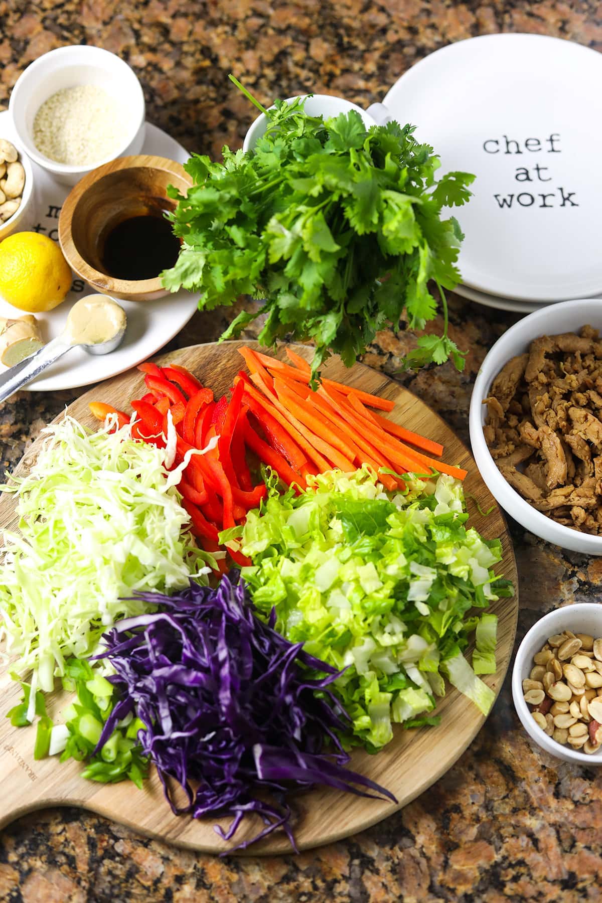 Overlay of asian salad ingredients, cabbages thinly sliced, romaine lettuce, marinade, on cutting board