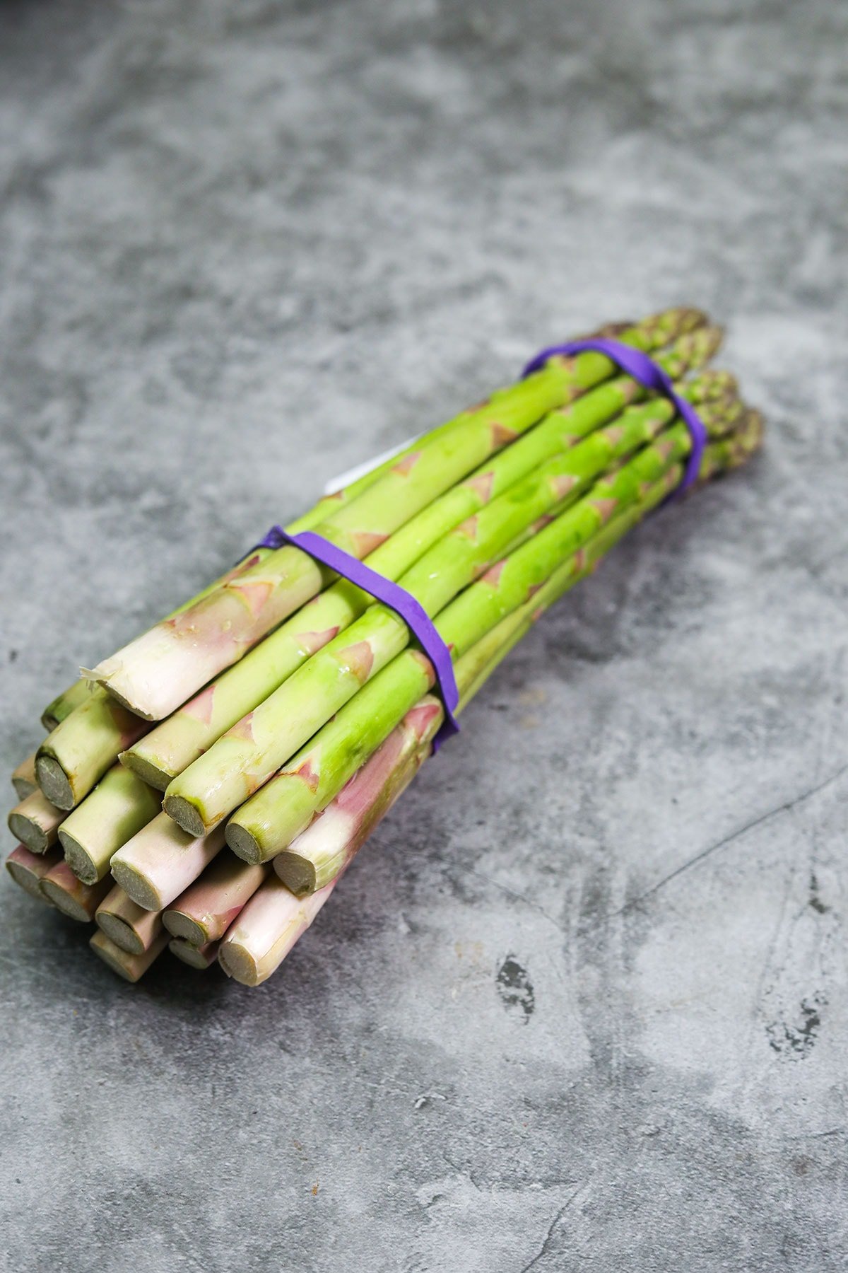 asparagus bunch tied with elastic bands on a counter