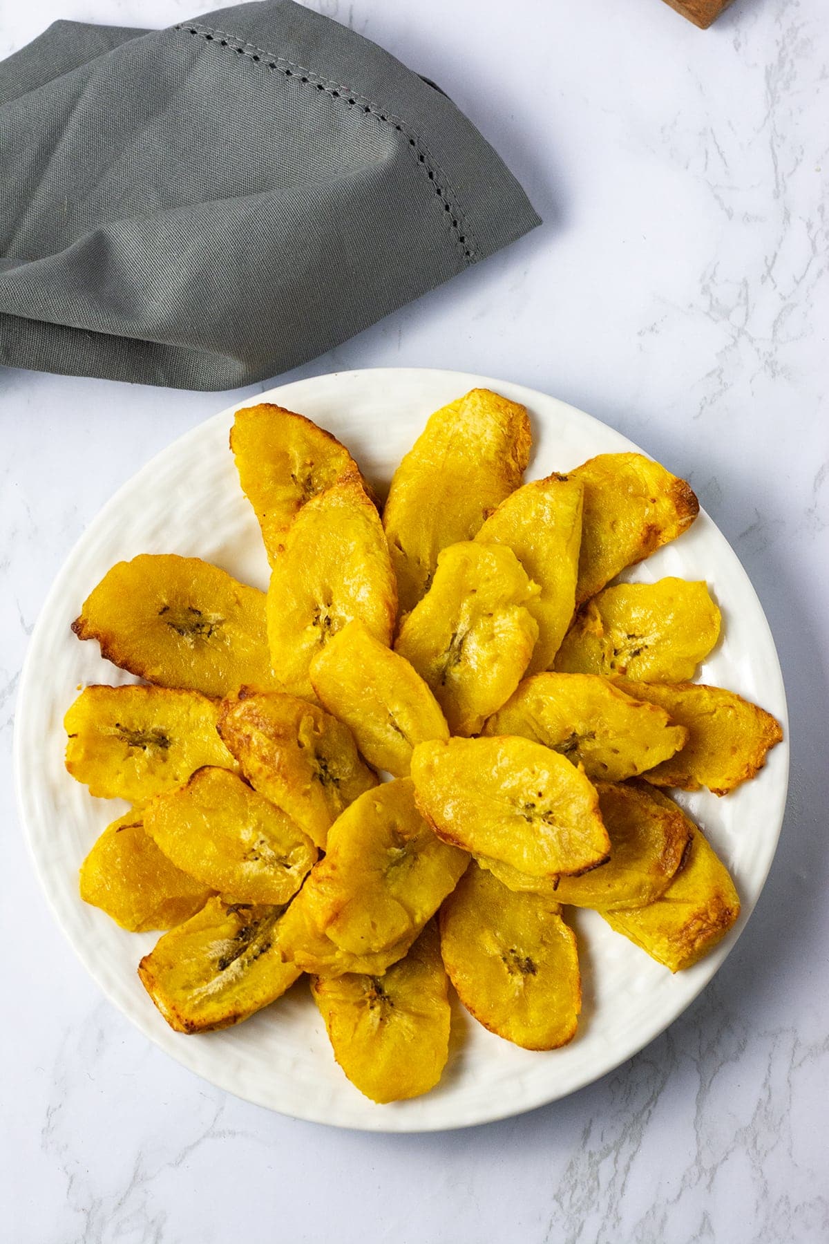 air fried plantains in a pile on a white plate