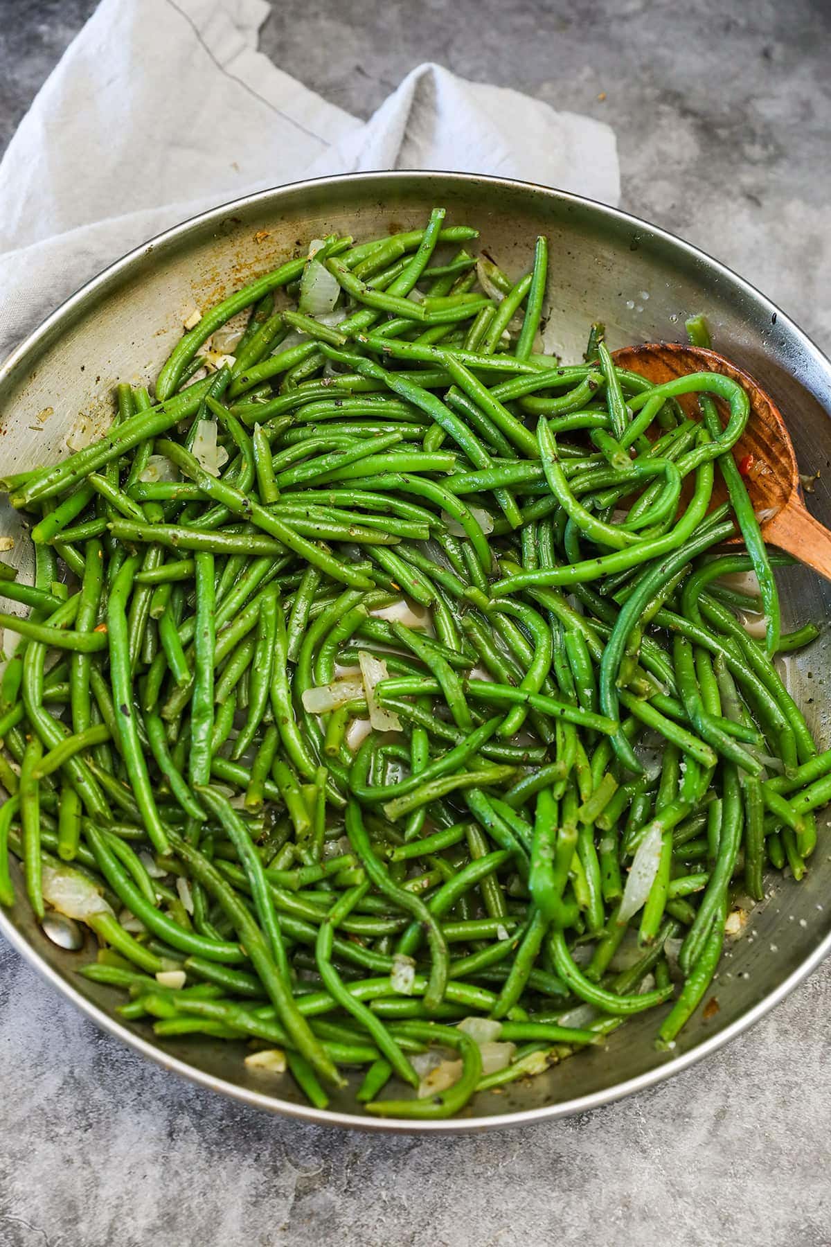 frozen green beans in skillet on grey background