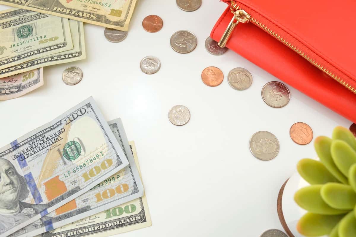 pile of money on desk next to purse