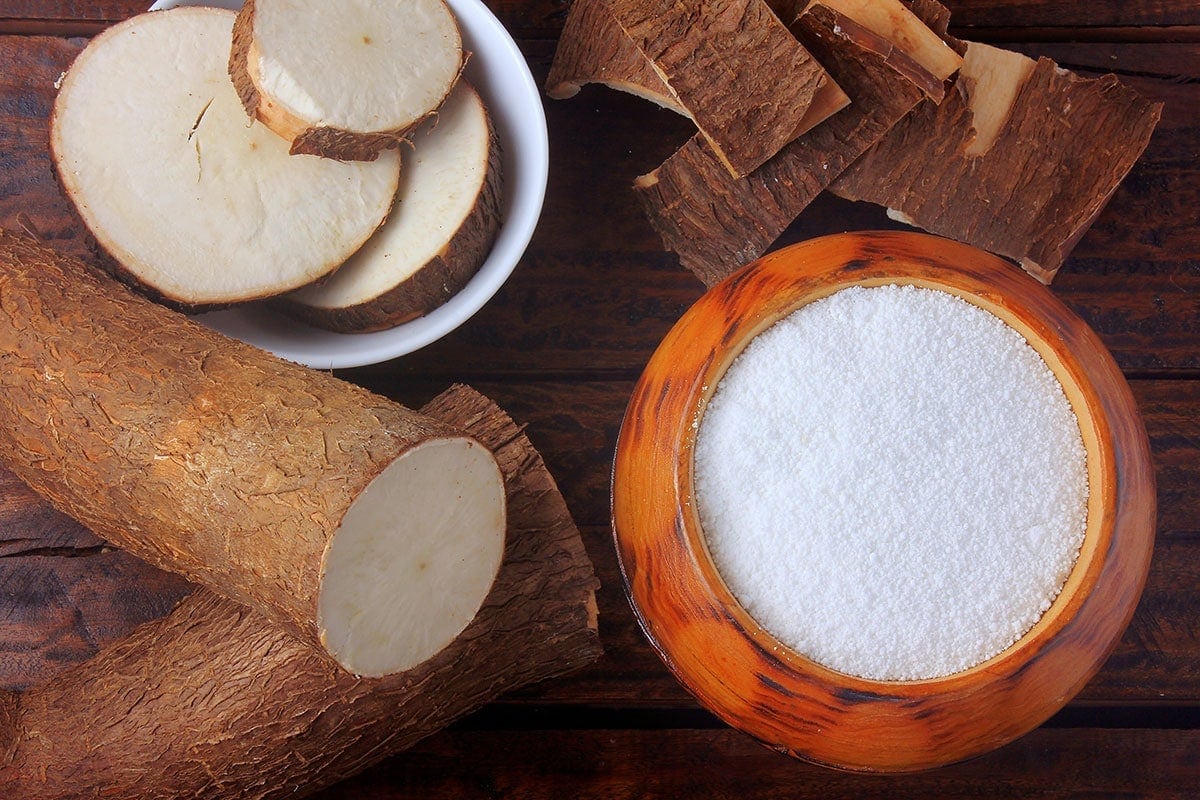 tapioca starch in a wooden bowl with cassava cut in slices. A great Arrowroot Flour Substitute