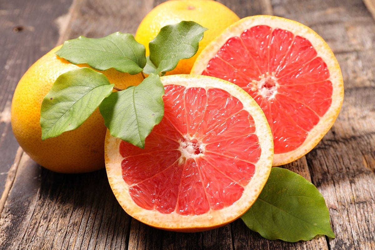 Grapefruit cut in halves on wooden background