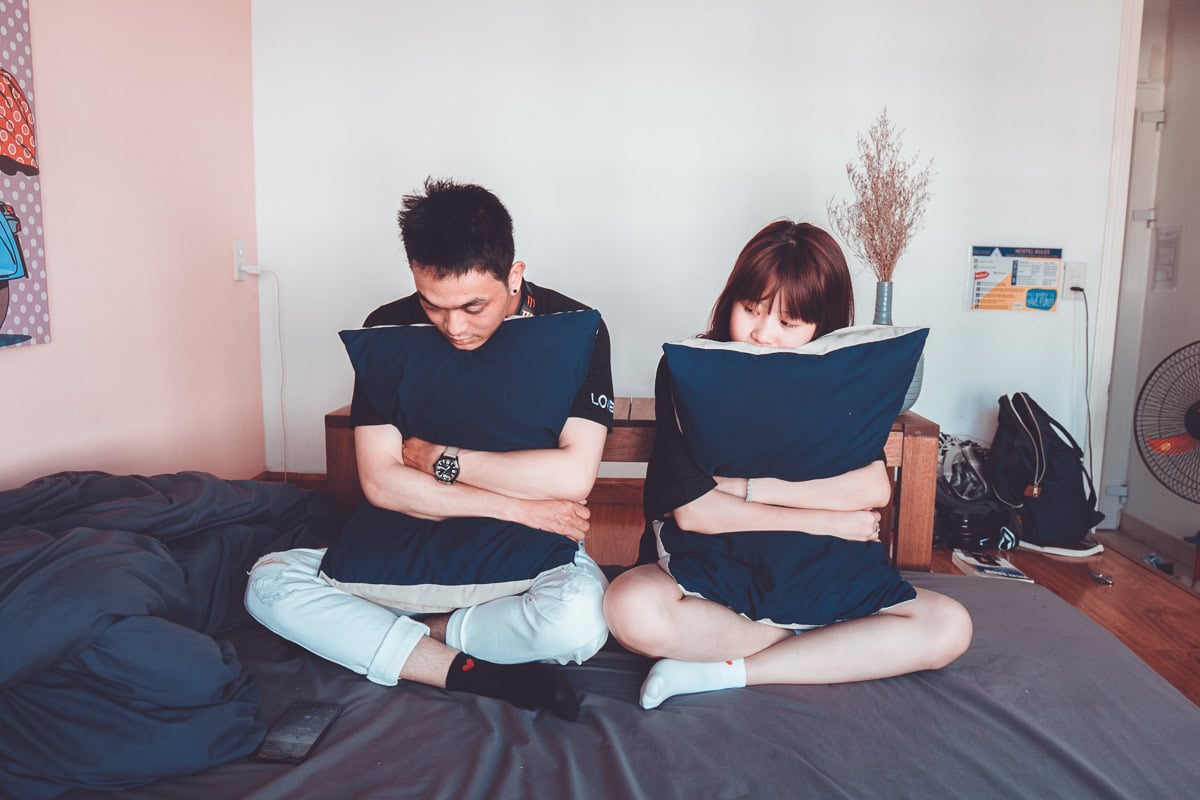 A couple having a fight on a bed.
