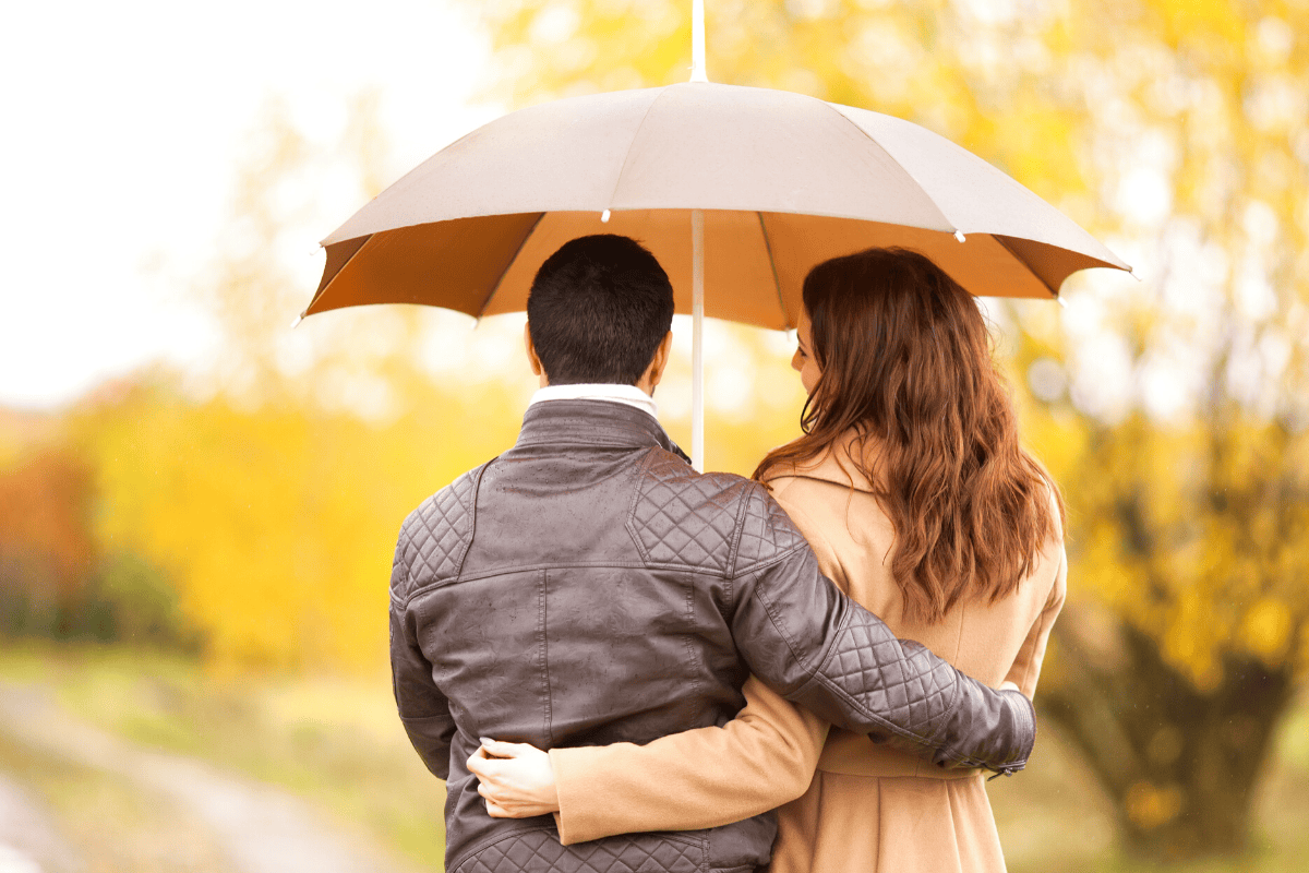 Couple going on a walk under an umbrella.