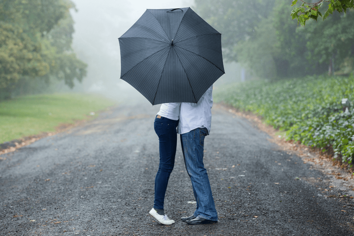 Couple kissing under an umbrella