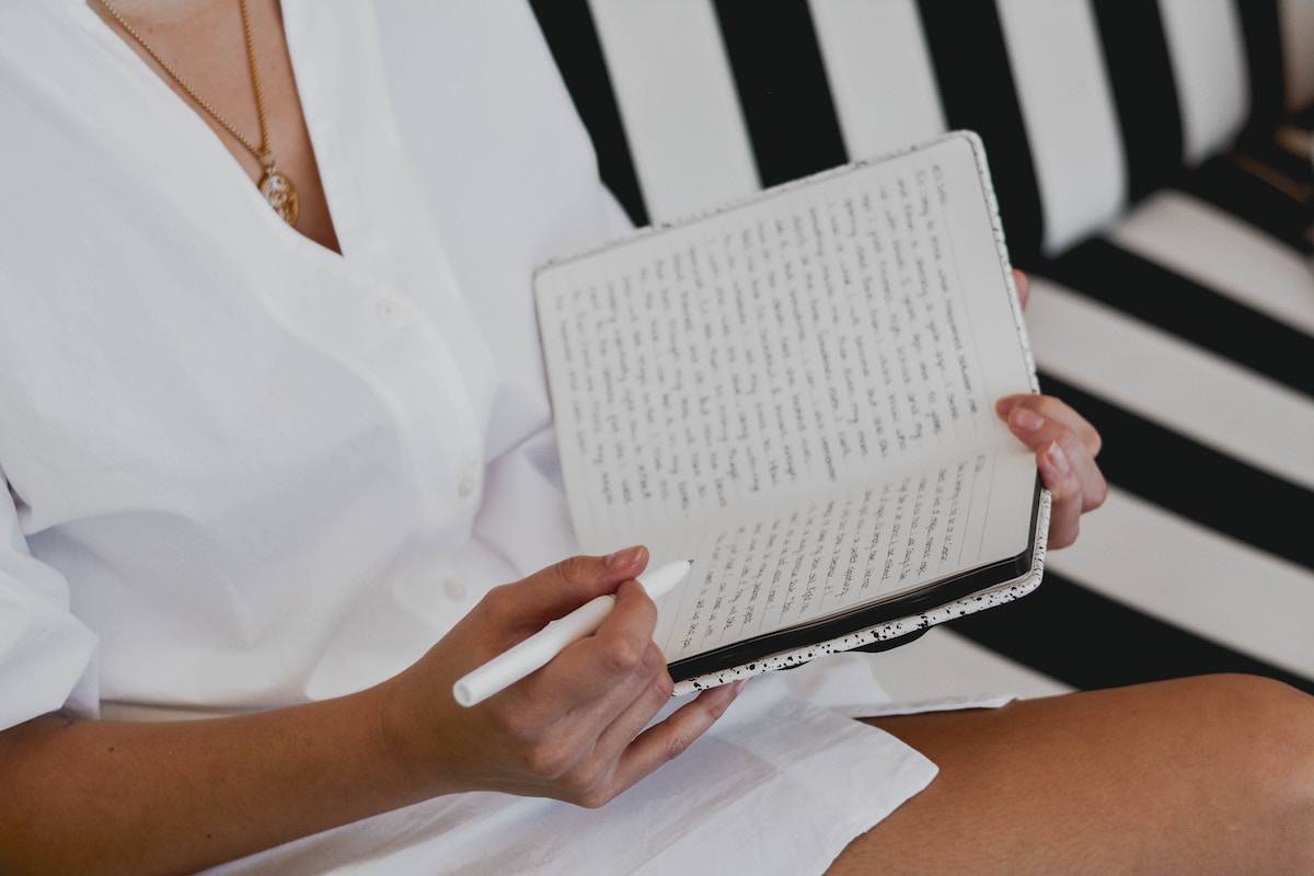 women writing large amounts in a journal